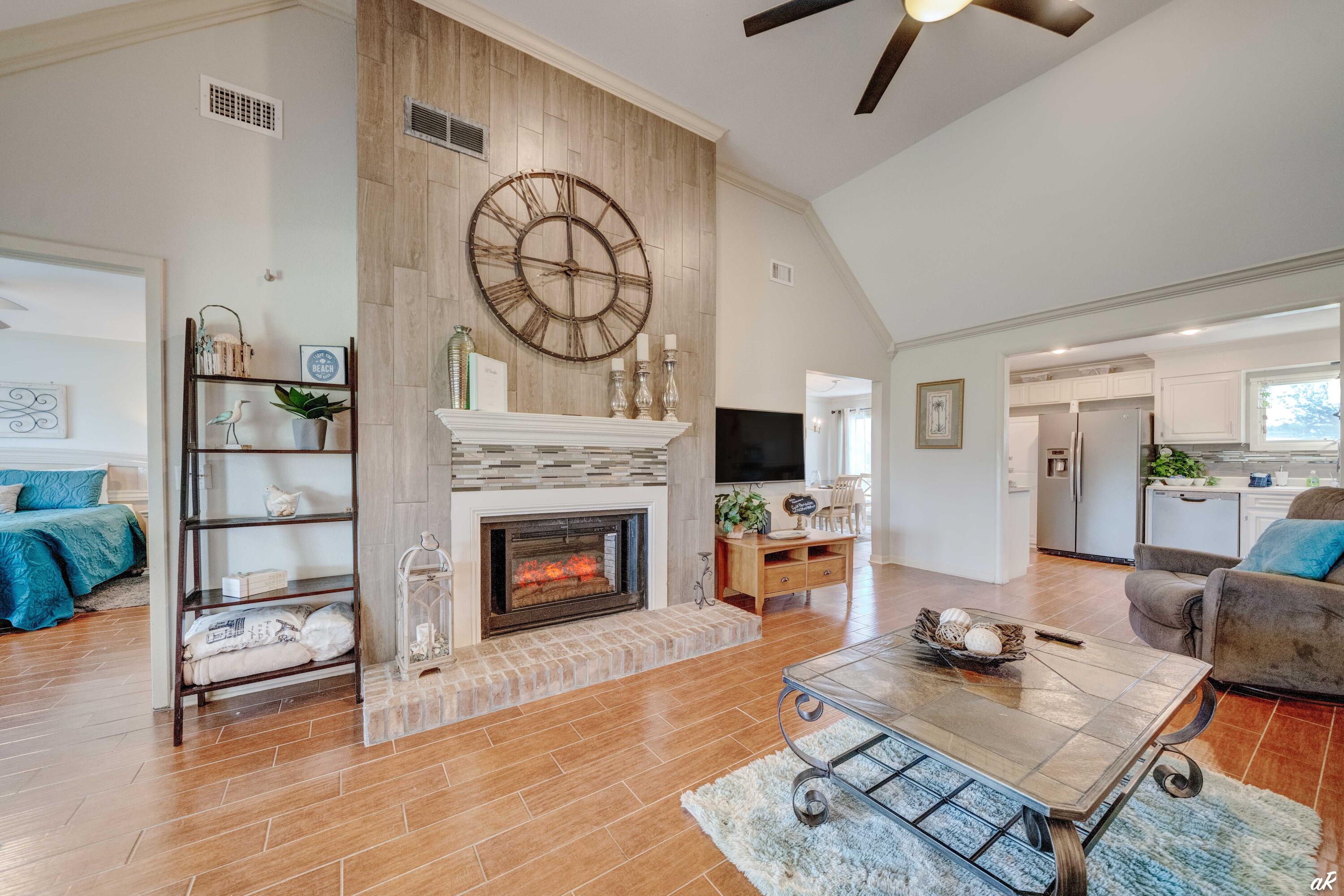 4300 Bay Point Road, Unit 417 Panama City Beach, FL 32408 - Photo 3 of 35 a living room with furniture a fireplace and a flat screen tv