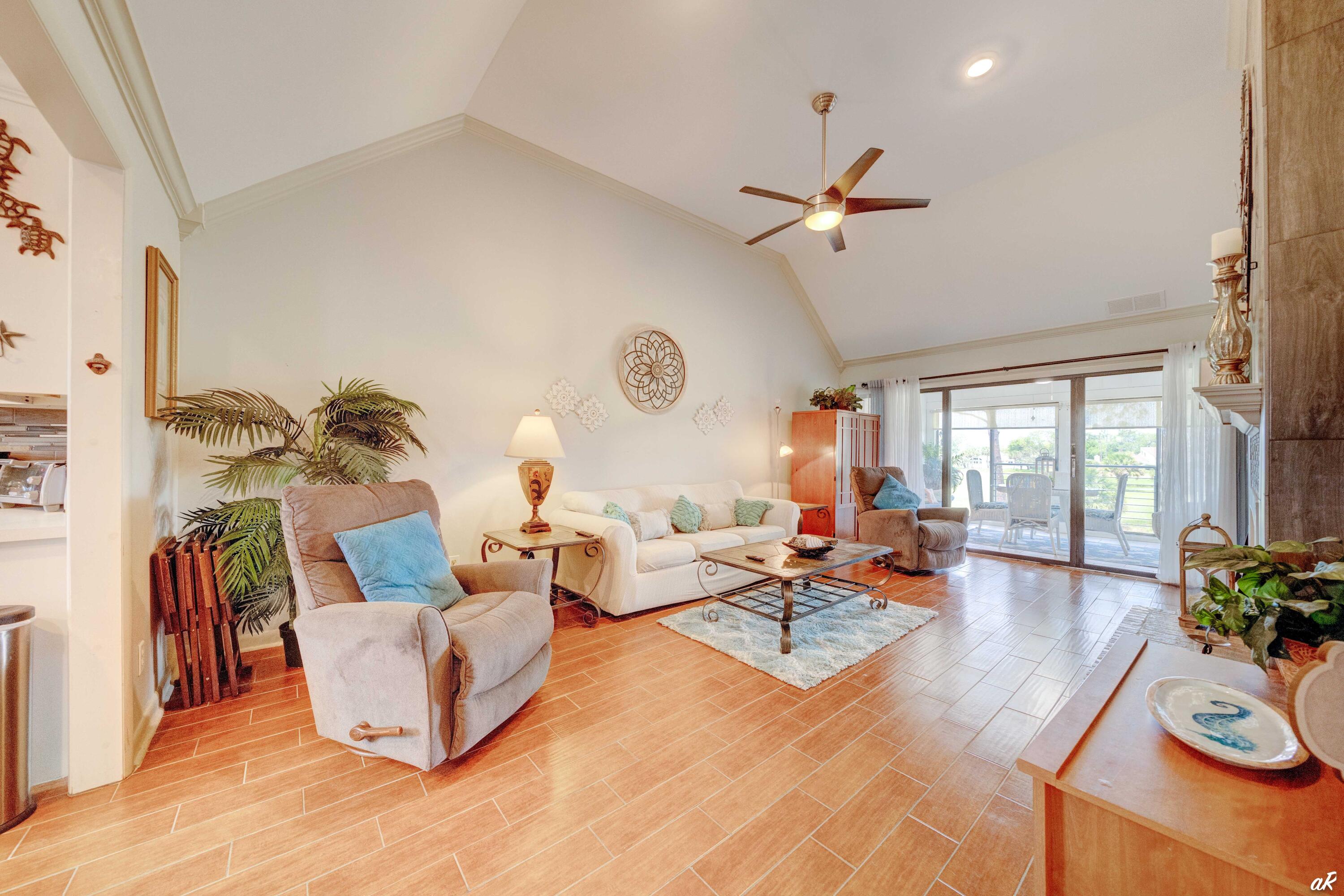 4300 Bay Point Road, Unit 417 Panama City Beach, FL 32408 - Photo 5 of 35 a living room with fireplace furniture and a large window
