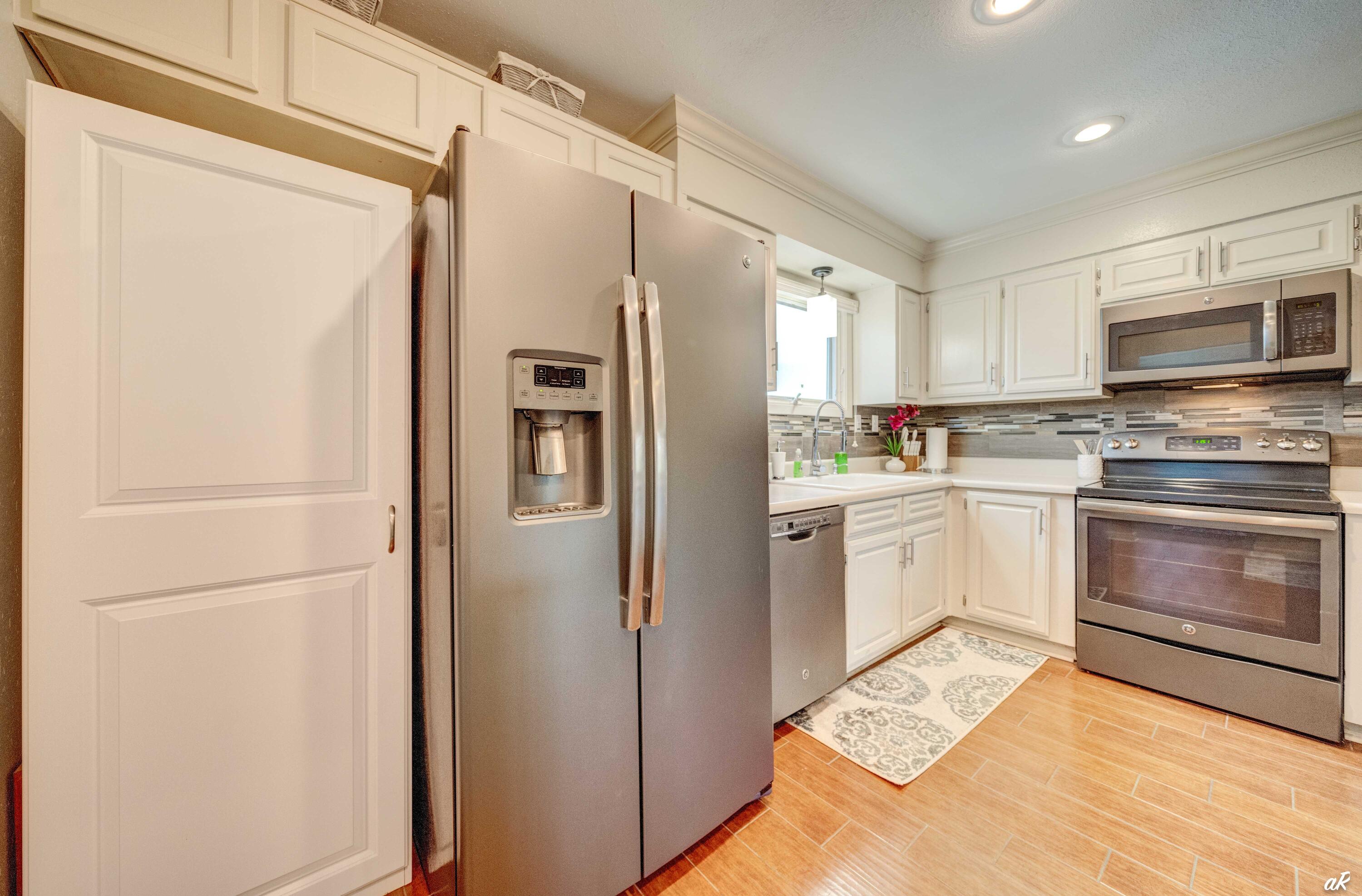 4300 Bay Point Road, Unit 417 Panama City Beach, FL 32408 - Photo 8 of 35 a kitchen with a refrigerator a stove top oven and kitchen island