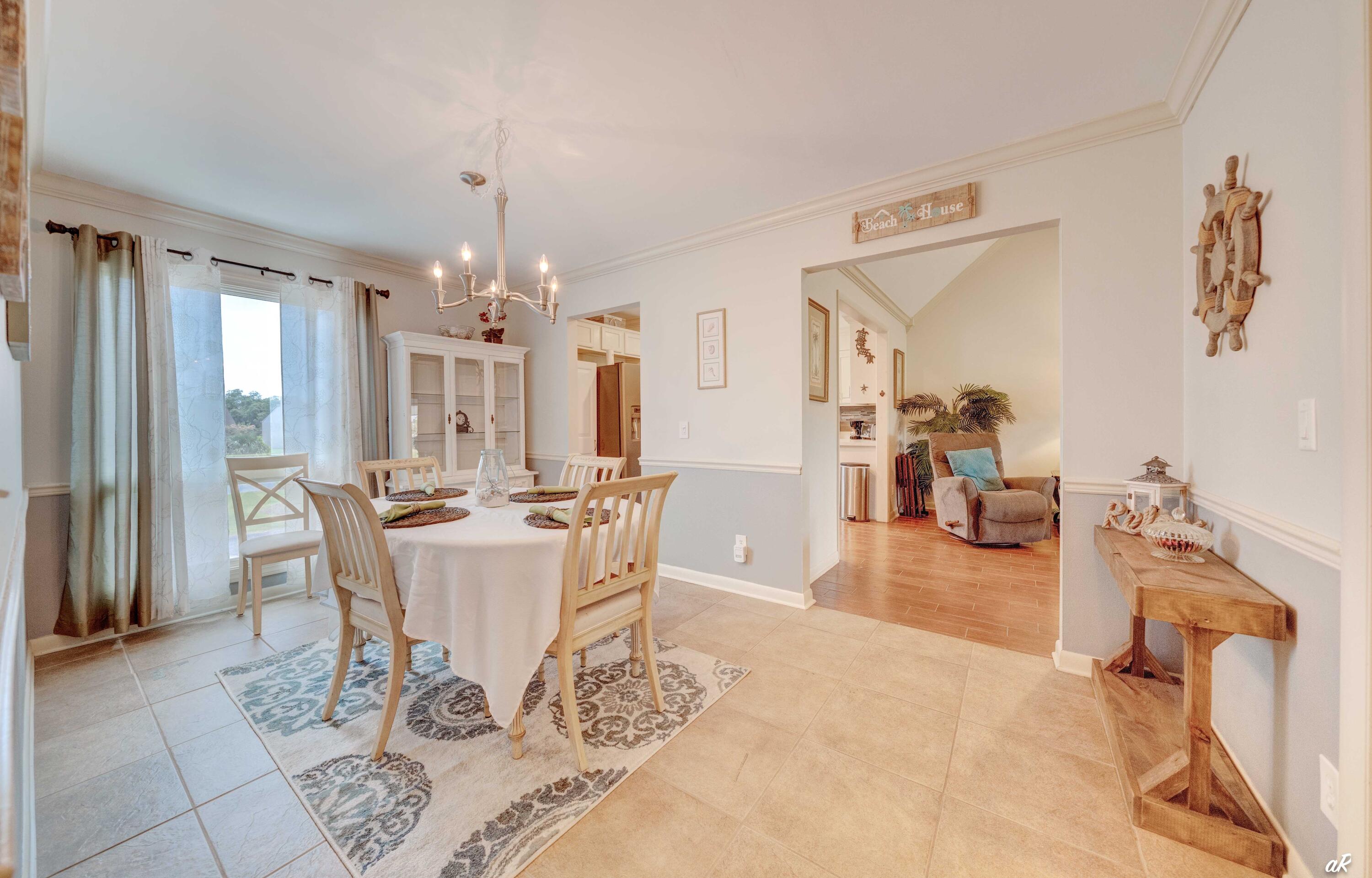 4300 Bay Point Road, Unit 417 Panama City Beach, FL 32408 - Photo 9 of 35 a view of a dining room with furniture and chandelier