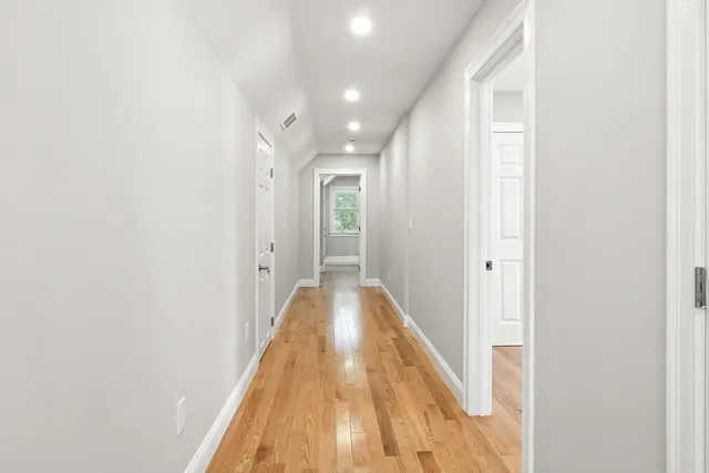 a view of a hallway with wooden floor