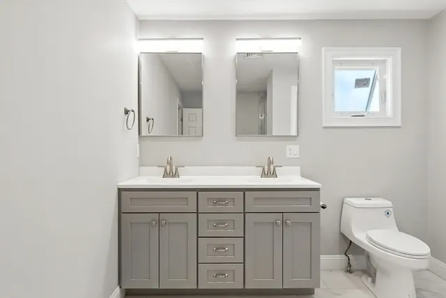 a bathroom with a toilet sink and mirror