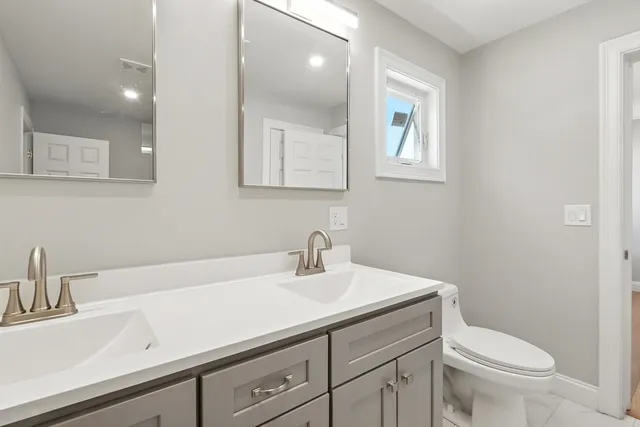 a bathroom with a sink a toilet and a mirror