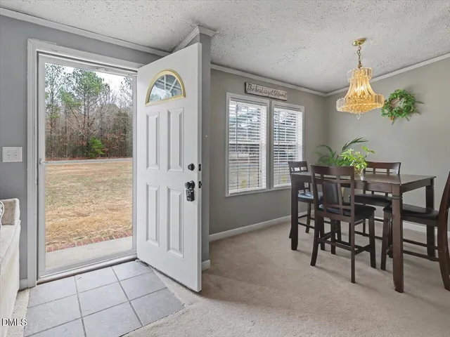 a dining room with furniture a chandelier and a rug