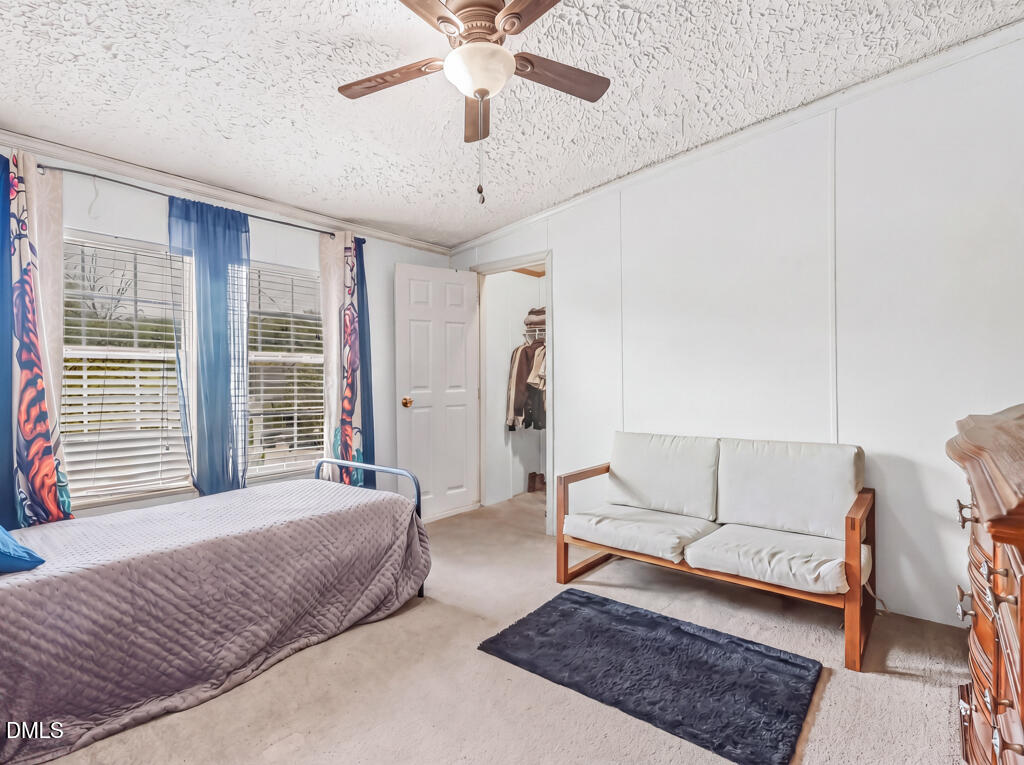 523 County Line Road Manson, NC 27553 - Photo 21 of 42 a spacious bedroom with a bed a couch and a chandelier