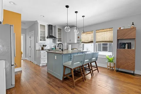 a kitchen with stainless steel appliances granite countertop wooden floors sink and cabinets