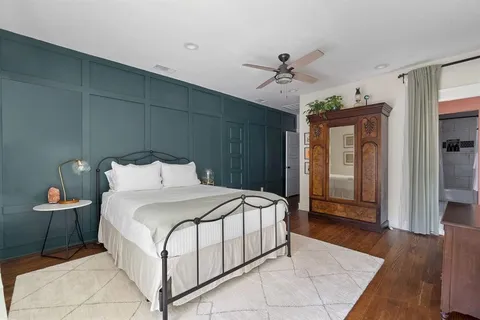 a spacious bedroom with a bed and wooden floor