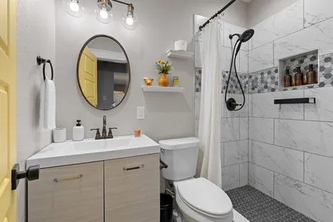 a bathroom with a sink a toilet and shower