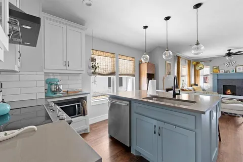 a kitchen with stainless steel appliances granite countertop a stove a sink and a white refrigerator