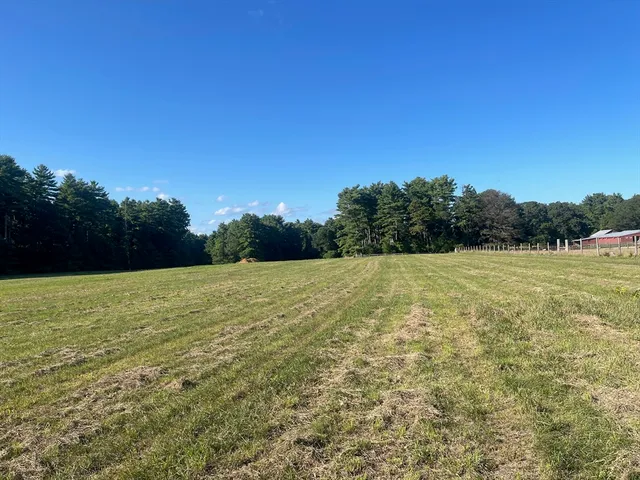 a view of a green field with wooden fence