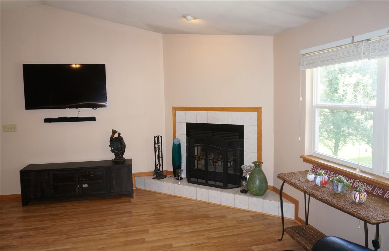 304 Rochester Road Northeast Poplar Grove, IL 61065 - Photo 8 of 23 a living room with furniture a flat screen tv and a fireplace