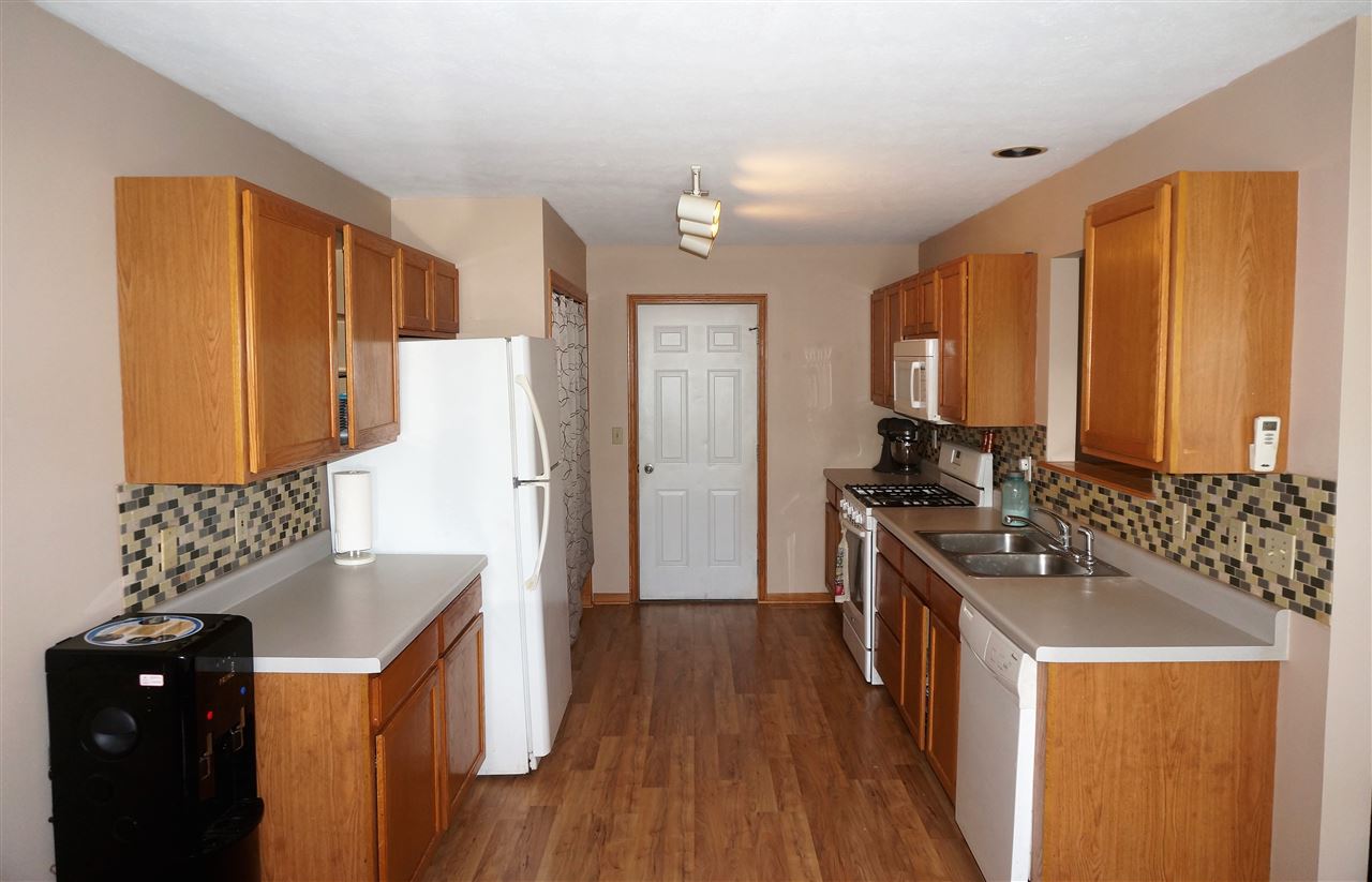 304 Rochester Road Northeast Poplar Grove, IL 61065 - Photo 10 of 23 a kitchen with stainless steel appliances granite countertop a refrigerator a stove a sink dishwasher and a dining table with wooden floor