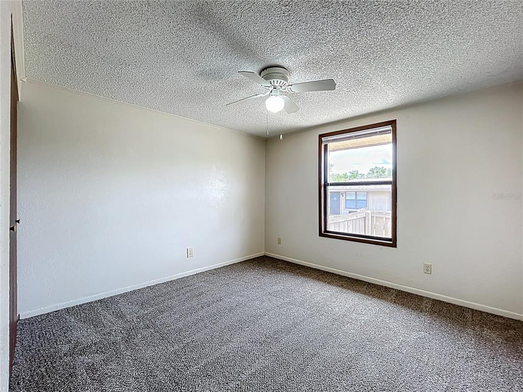 611 Mt Homer Road Eustis, FL 32726 - Photo 11 of 20 an empty room with chandelier fan and windows