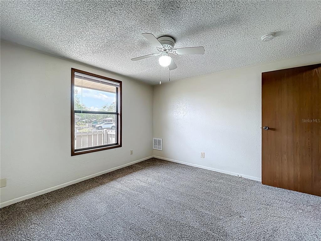 611 Mt Homer Road Eustis, FL 32726 - Photo 12 of 20 an empty room with ceiling fan and window