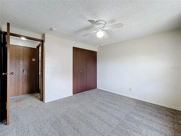 a view of an empty room with a ceiling fan