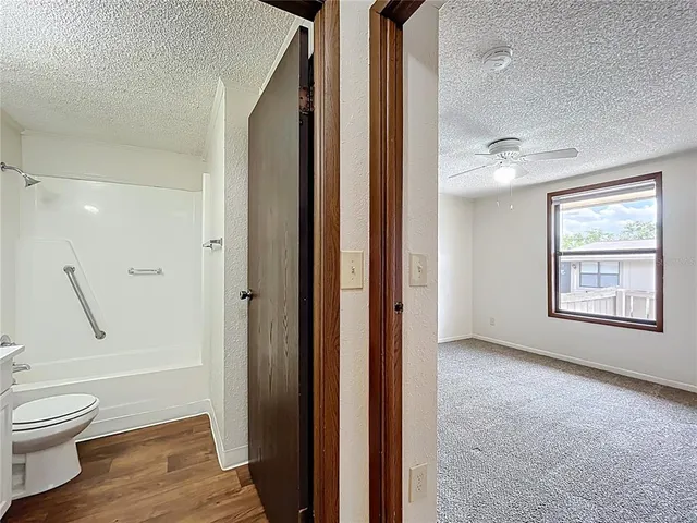 a bathroom with a granite countertop toilet a sink and a mirror