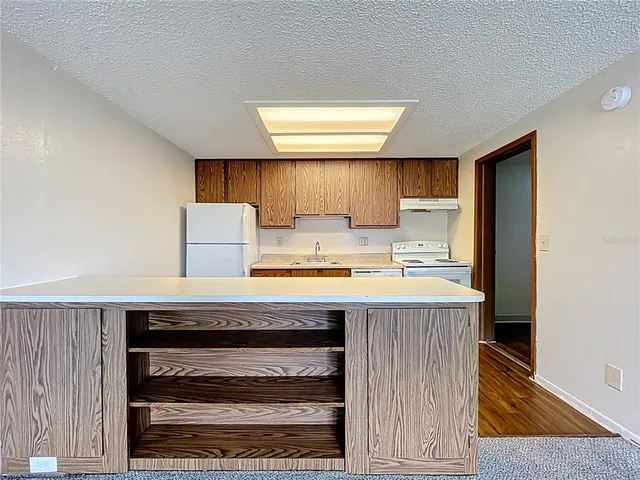 a view of kitchen with sink and refrigerator