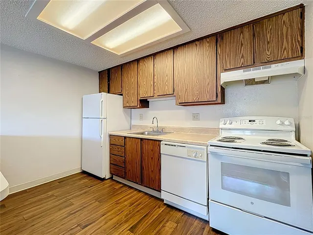 a kitchen with a sink cabinets stainless steel appliances and a window