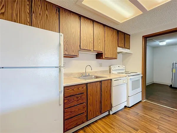 a kitchen with a sink a stove a refrigerator and cabinets