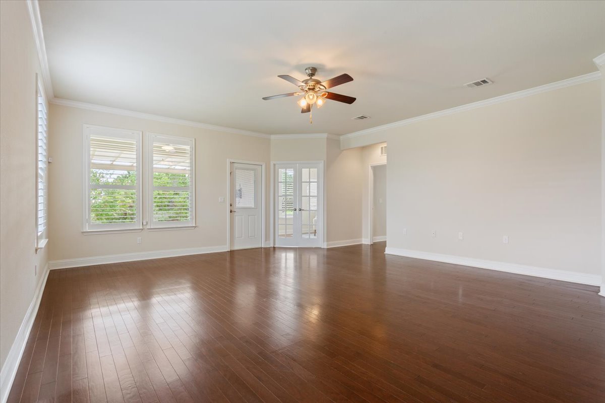 905 Mount Locke Court Georgetown, TX 78633 - Photo 16 of 36 an empty room with wooden floor chandelier fan and windows