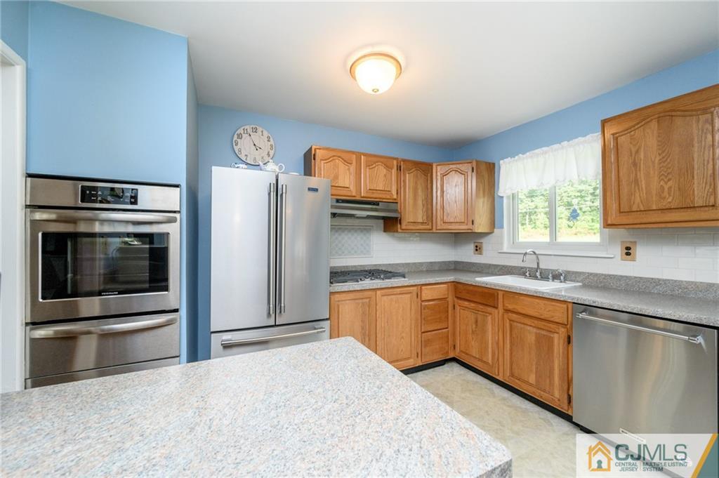 25 Drexel Drive Jackson, NJ 08527 - Photo 15 of 34 a kitchen with stainless steel appliances granite countertop a stove a sink and a microwave