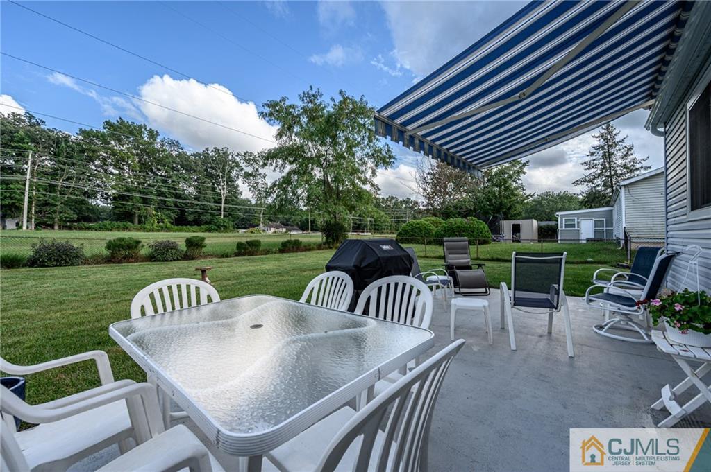 25 Drexel Drive Jackson, NJ 08527 - Photo 32 of 34 a view of a patio with a table chairs and a backyard