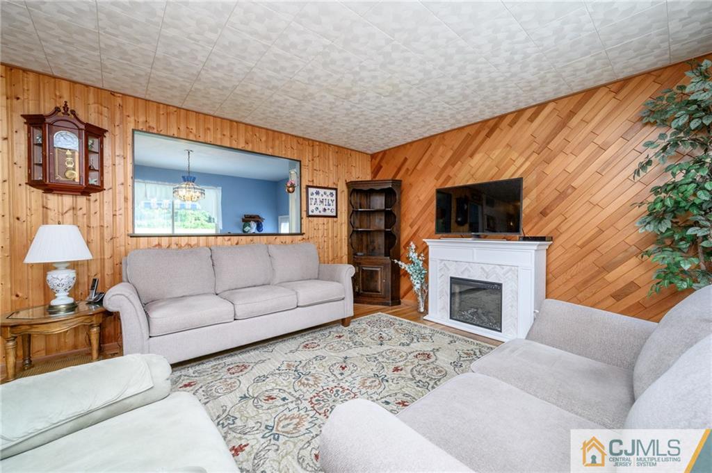 25 Drexel Drive Jackson, NJ 08527 - Photo 6 of 34 a living room with furniture a flat screen tv and a fireplace