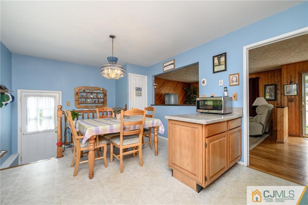 25 Drexel Drive Jackson, NJ 08527 - Photo 10 of 34 a dining hall with stainless steel appliances granite countertop a stove a sink a dining table and chairs with wooden floor