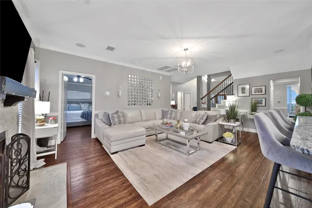 a living room with furniture or chandelier and a wooden floor