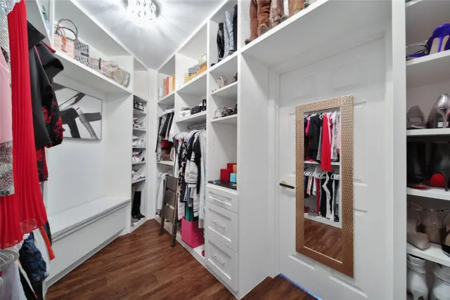 a view of walk in closet with clothes and shoes