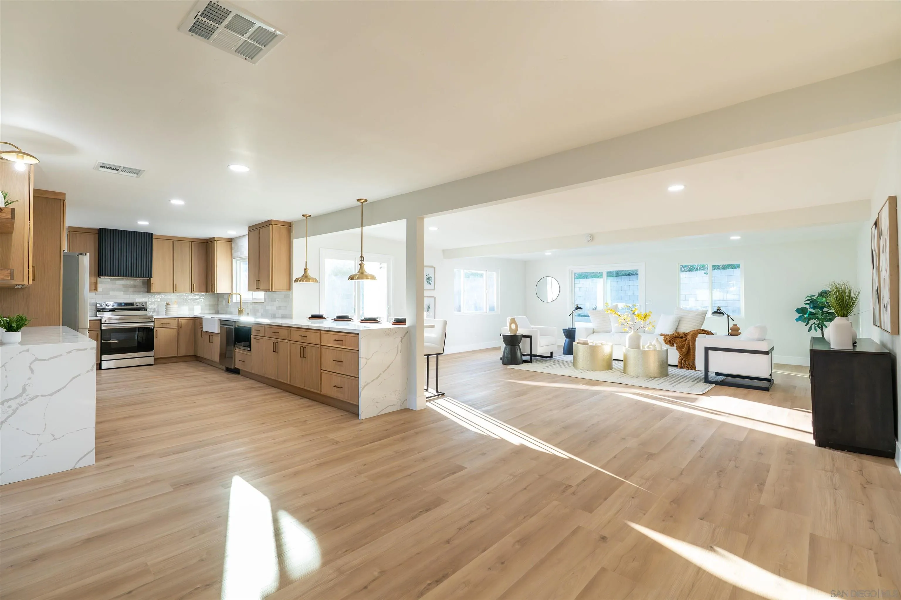 4112 Lois Street La Mesa, CA 91941 - Photo 4 of 39 a large living room with stainless steel appliances kitchen island granite countertop a large window and a couch