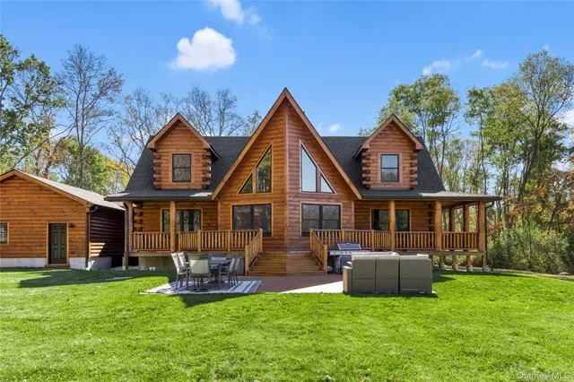 a backyard of a house with lots of green space and outdoor seating