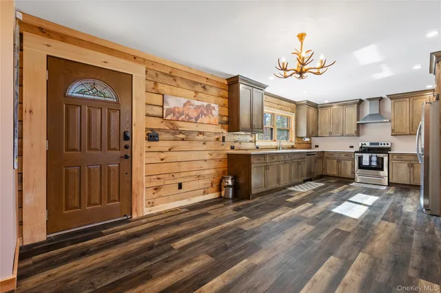a view of a kitchen with kitchen island stainless steel appliances refrigerator stove microwave and cabinets