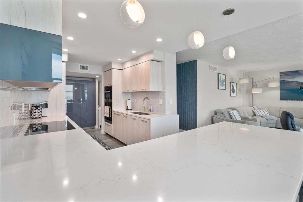 1050 Longboat Club Road, Unit 901 Longboat Key, FL 34228 - Photo 11 of 37 a large white kitchen with kitchen island a sink stainless steel appliances and cabinets