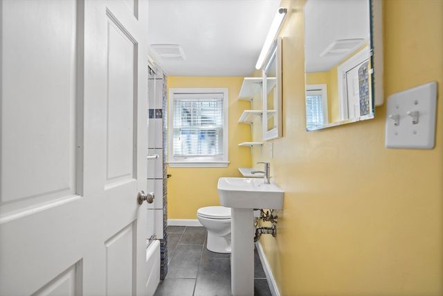 a bathroom with a toilet sink and a mirror