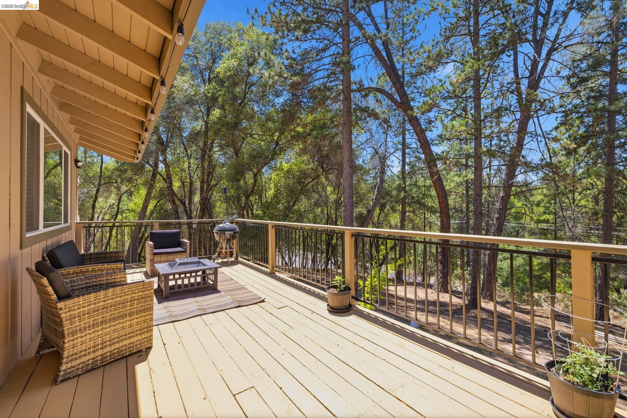 19059 Raboul Court Groveland, CA 95321 - Photo 17 of 21 Expansive deck featuring wood-finish flooring, a wood railing with black spindles, and a light tan exterior wall