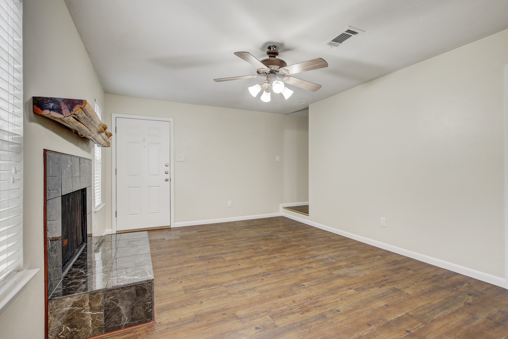 6902 Rifle Bend Austin, TX 78736 - Photo 11 of 33 a view of an empty room with wooden floor and a fireplace