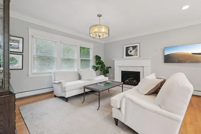 a living room with furniture a large window and a fireplace