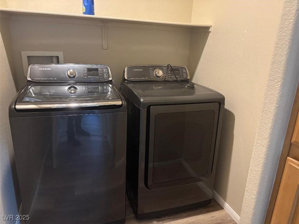 8690 West Diamond Sand Avenue Las Vegas, NV 89178 - Photo 18 of 25 Laundry room featuring light wood-style flooring, a textured wall, and washing machine and dryer