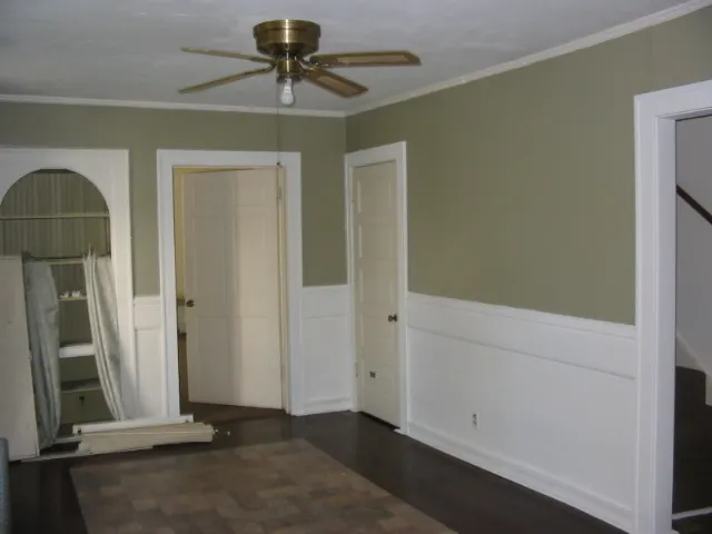 a view of a livingroom with a chandelier fan and a hallway
