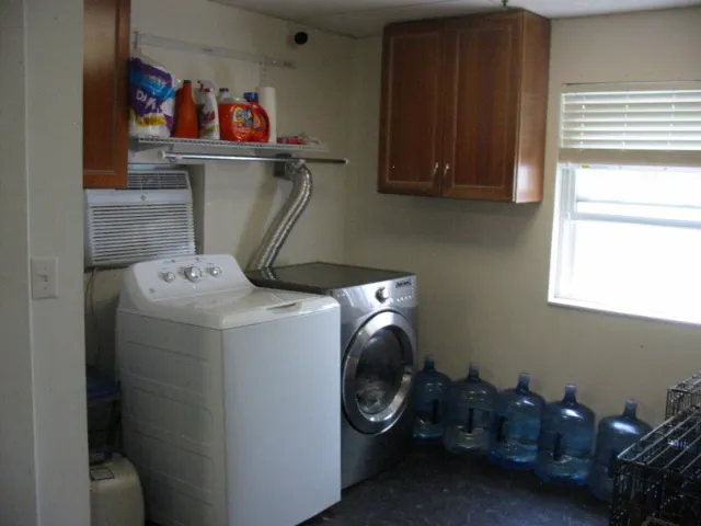 a utility room with dryer washer and a fridge