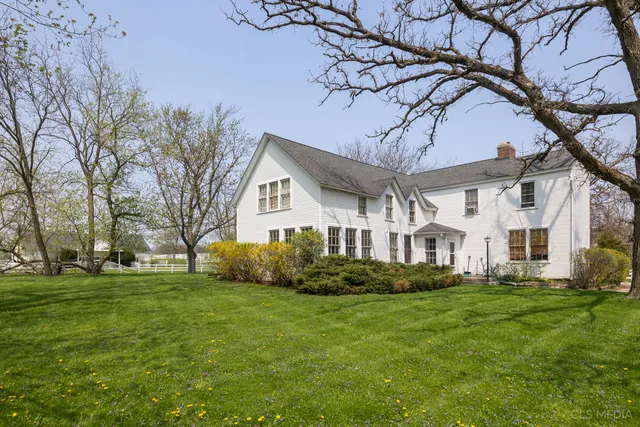 a front view of a house with a garden and trees