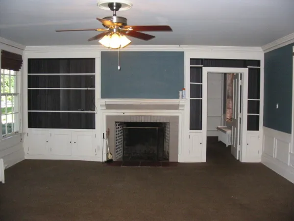 a living room with a fireplace and a ceiling fan