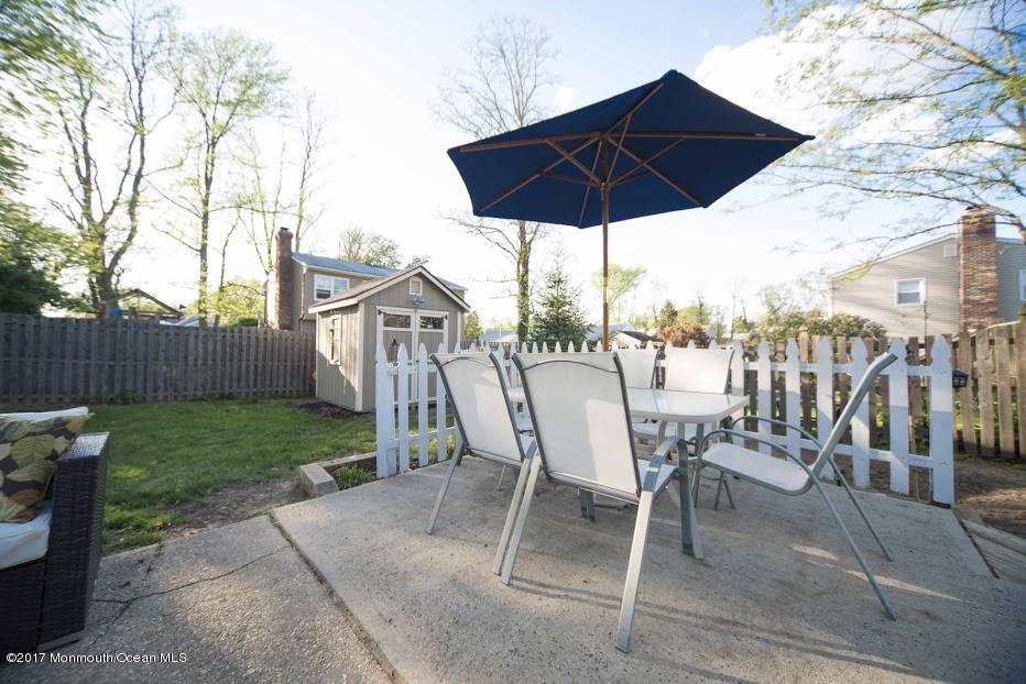402 Maple Drive Belford, NJ 07718 - Photo 17 of 18 a view of a chairs and table under an umbrella