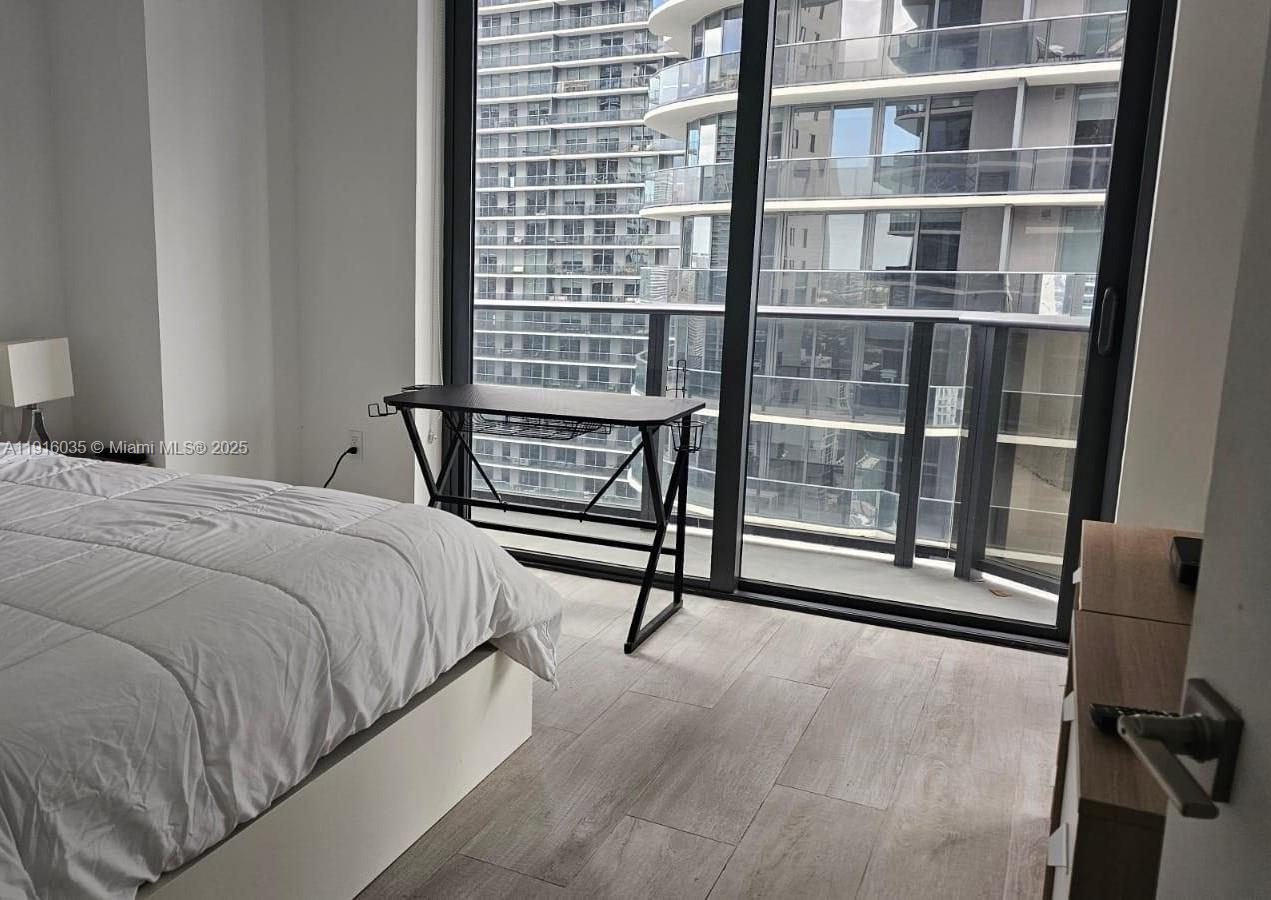 55 Southwest 9th Street, Unit 2902 Miami, FL 33130 - Photo 21 of 22 a bedroom with a bed and a book shelf