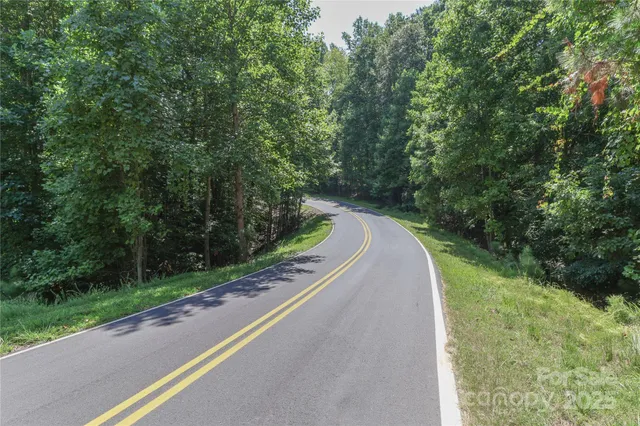 a view of a road with a yard and a trees