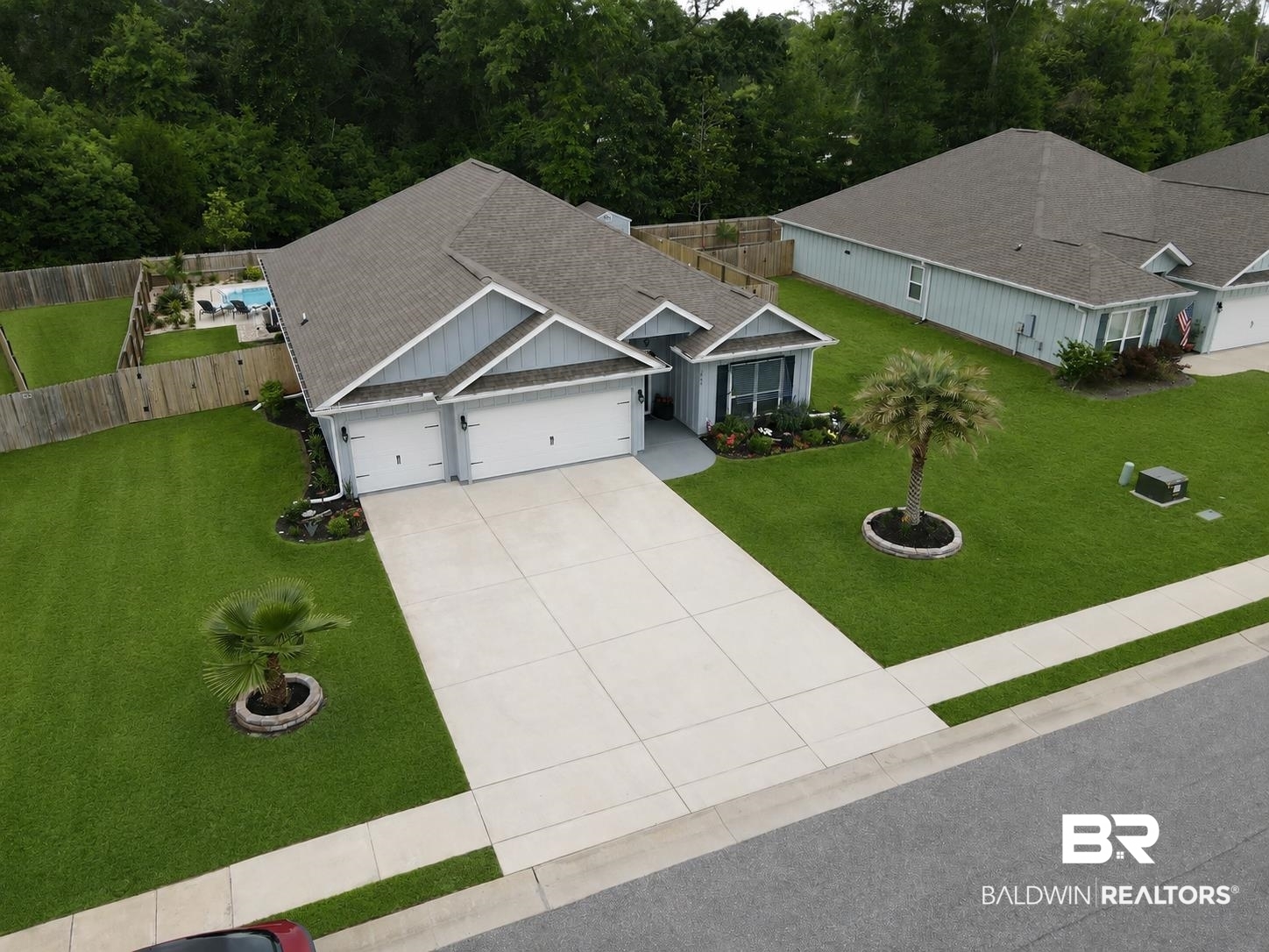 1885 Carly Street Foley, AL 36535 - Photo 3 of 40 Contemporary single-story residence featuring a two-car garage, light blue siding, and a gabled roofline