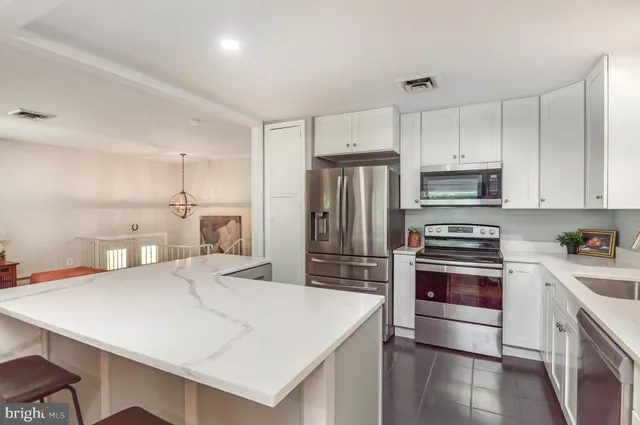 a kitchen with stainless steel appliances a stove refrigerator sink and cabinets