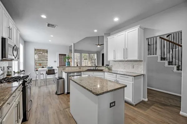 a kitchen with stainless steel appliances granite countertop a sink stove and refrigerator