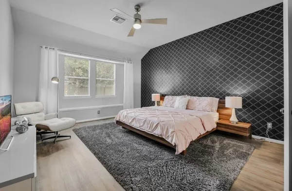 a bedroom with a bed and wooden floor